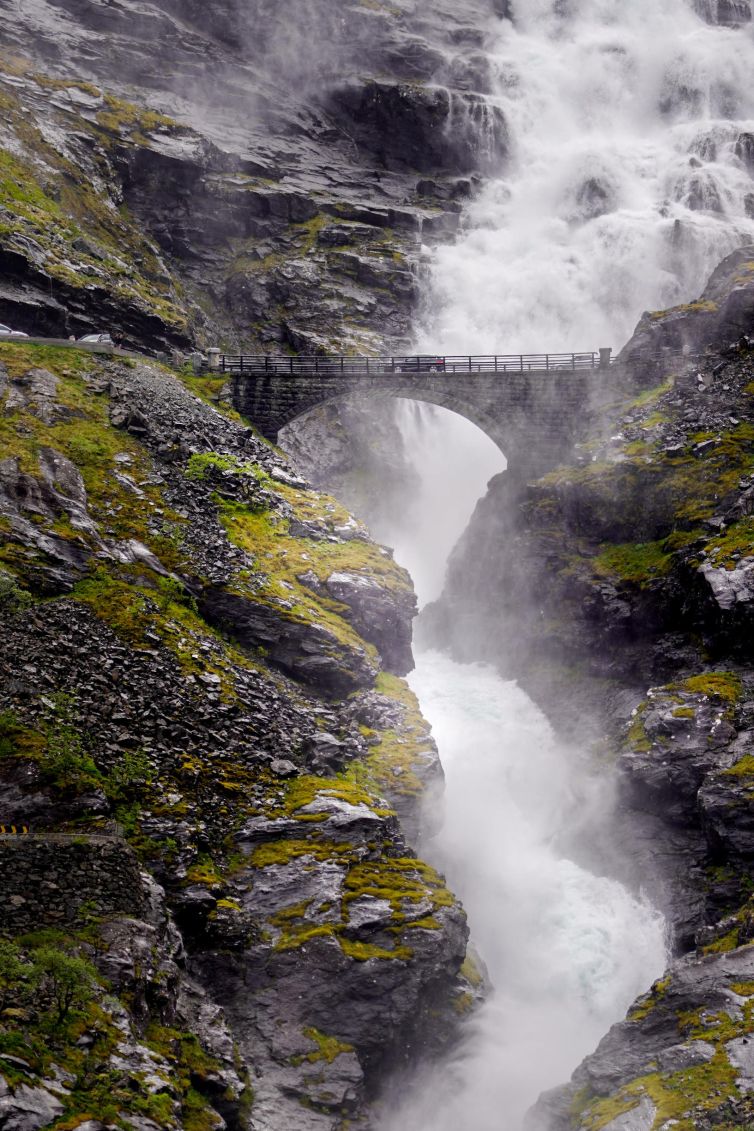 Waterfall cascading through cliffs with a bridge above in Møre og Romsdal, Norway.
