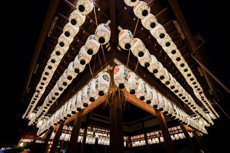 Traditional lanterns illuminating a structure in Kyoto, Japan at night.
