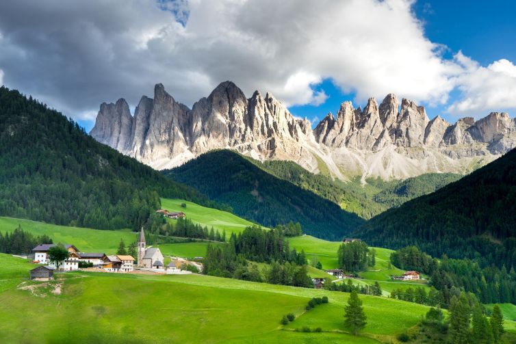 Scenic village nestled in a valley surrounded by Dolomite mountains in South Tyrol.