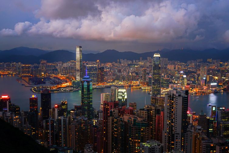 Vibrant twilight skyline of Hong Kong showcasing modern architecture and serene waters.