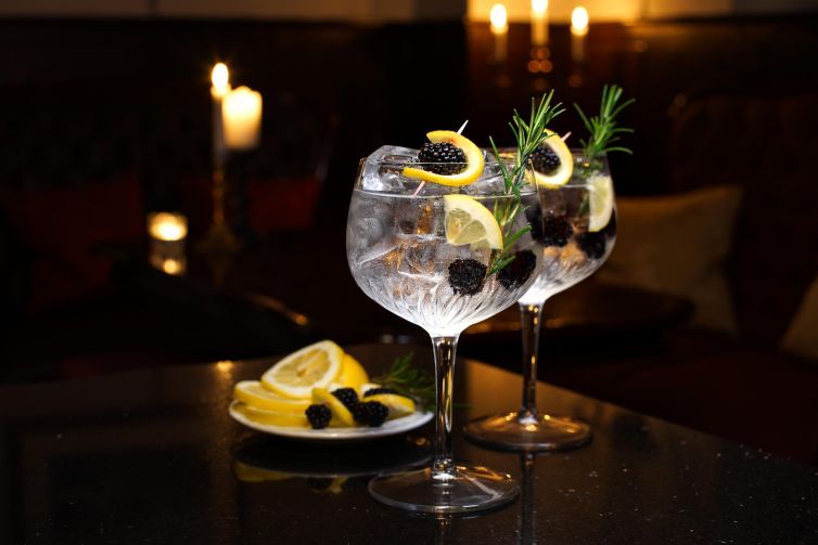 Charming drinks with lemon and rosemary in a cozy setting.