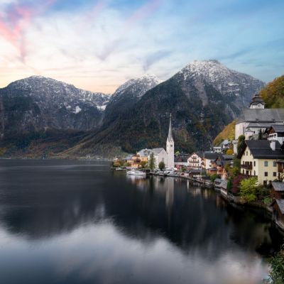 Peaceful Hallstatt village reflecting in the lake against mountainous backdrop in Austria.