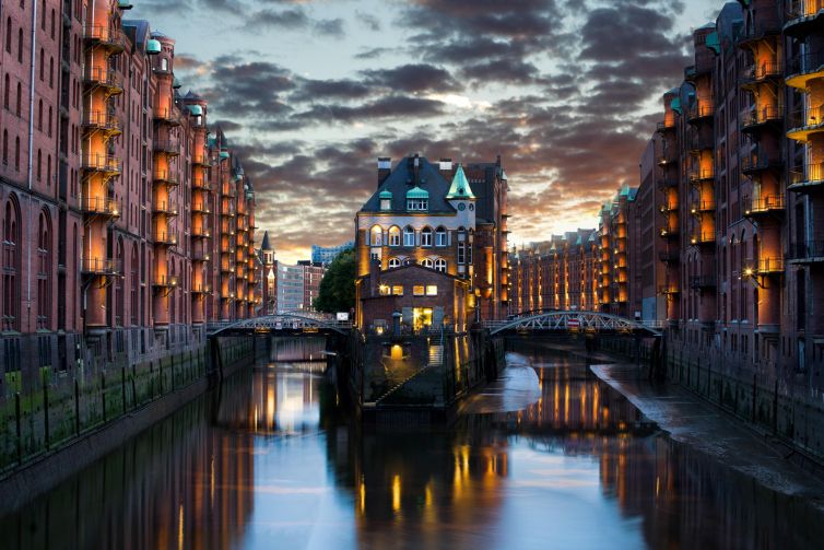 Old storage building at Hamburg river with vibrant lights and reflections at sunset.
