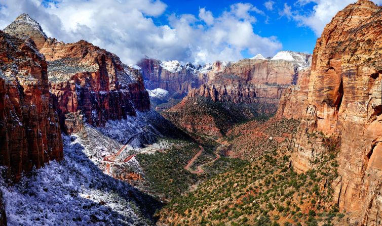 Zion National Park landscape featuring red cliffs, snow, and a winding road.