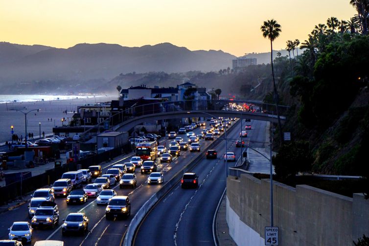 Santa Monica highway bustling with cars at dusk near the beach.
