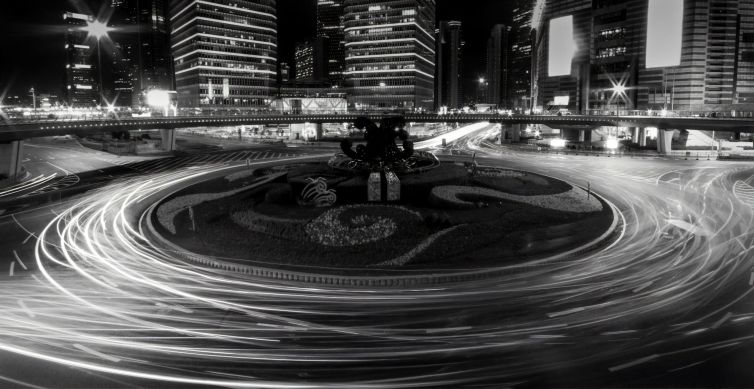 Night view of a roundabout in Shanghai with light trails and skyscrapers.