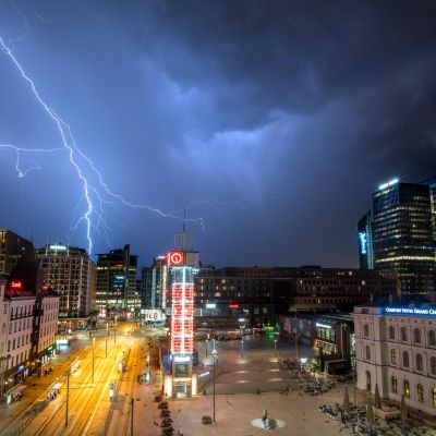 Stormy night over Oslo with dramatic lightning bolts illuminating the skyline.