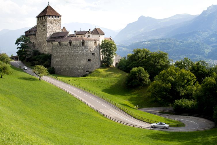 Vaduz Castle in Liechtenstein, surrounded by hills and scenic roads.