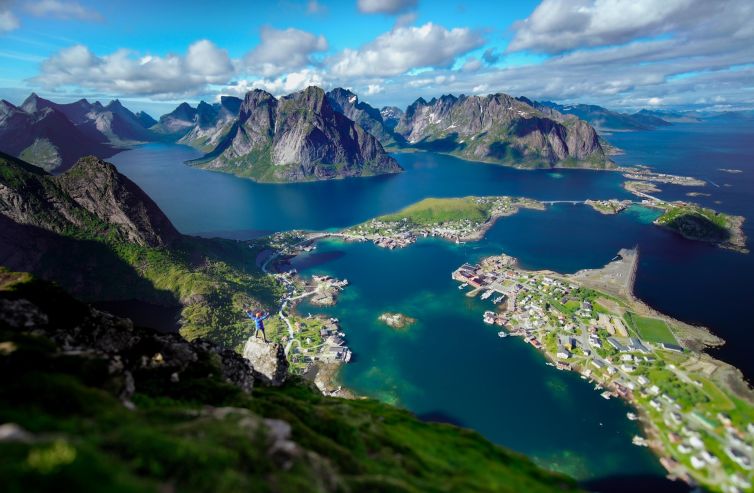 Aerial view of Reine, Norway, showcasing rugged mountains and picturesque coastal scenery.