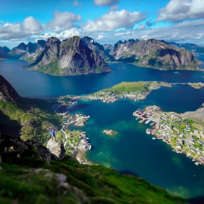 Aerial view of Reine, Norway, showcasing rugged mountains and picturesque coastal scenery.