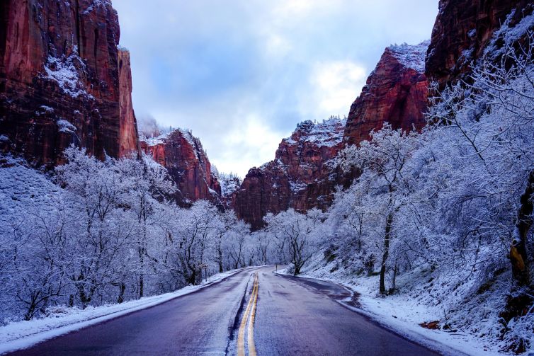 Winding road through a snow-covered landscape in Zion National Park, Utah.
